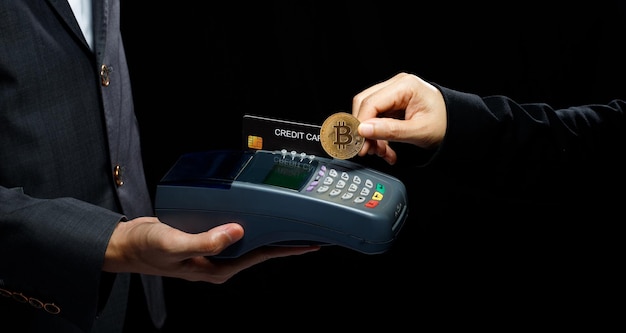 Payment with BTC Bitcoin will replace Credit Card and will be standard payment for every retail shop Shop cashier hold device for crypto currency payment Mockup copyspace over black background