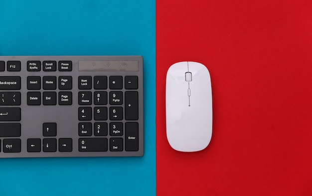 PC keyboard and mouse on red blue