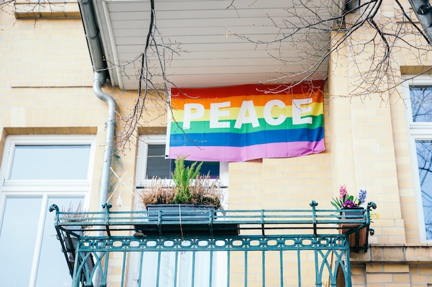 Peace rainbow flag on the balcony. Symbol, LGBT movement, text peace