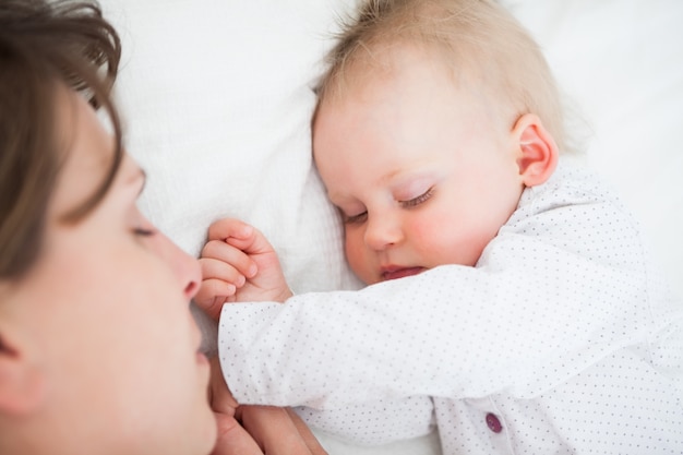 Peaceful baby sleeping next to her mother