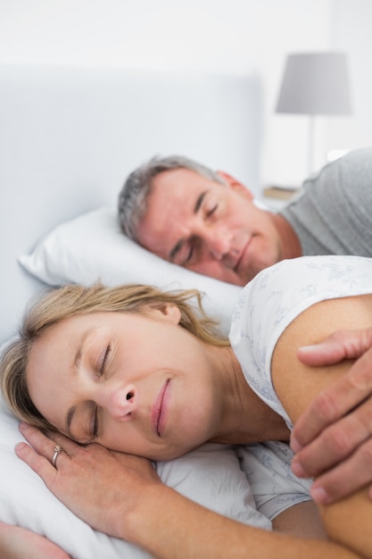 Peaceful couple sleeping and spooning in bed