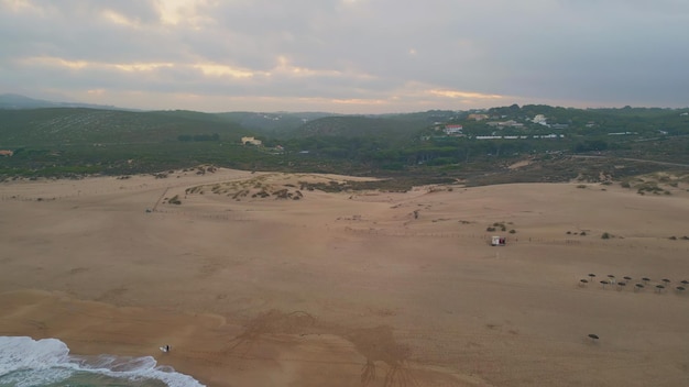 Peaceful evening seascape drone view foamy sea water rolling to sand seashore