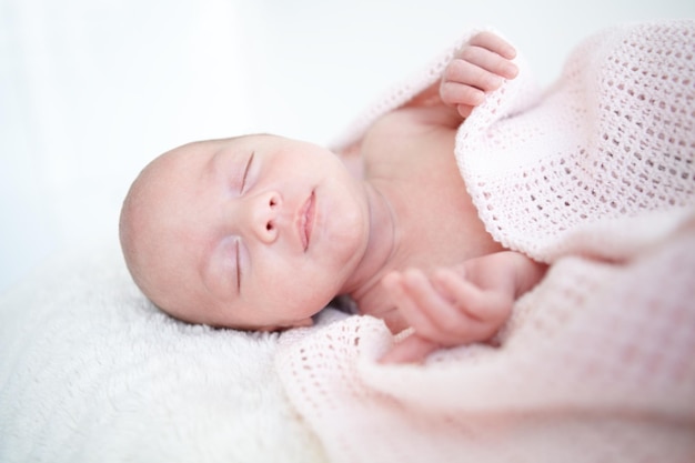 Peaceful sleep A beautiful infant girl sleeping while wrapped up in a blanket