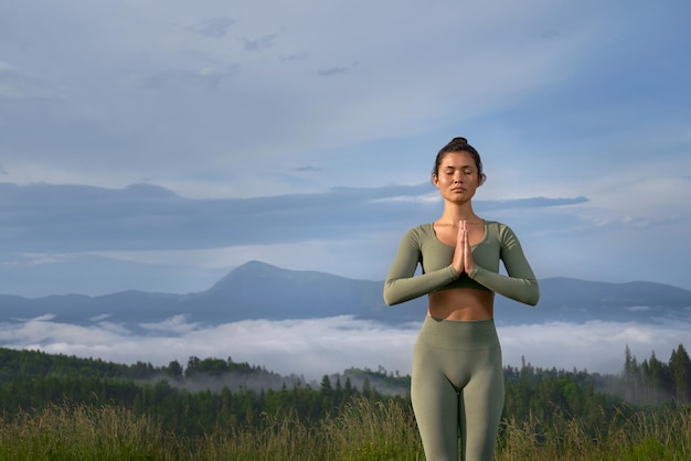 Peaceful woman meditating with view on mountains