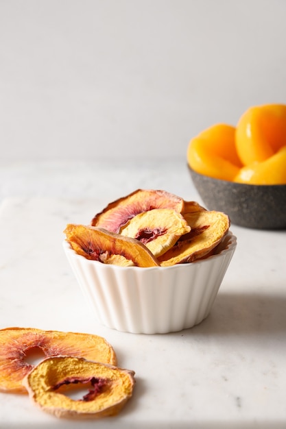 Peach chips in white bowl home drying