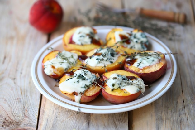 Peaches halves with blue cheese and thyme on a plate.