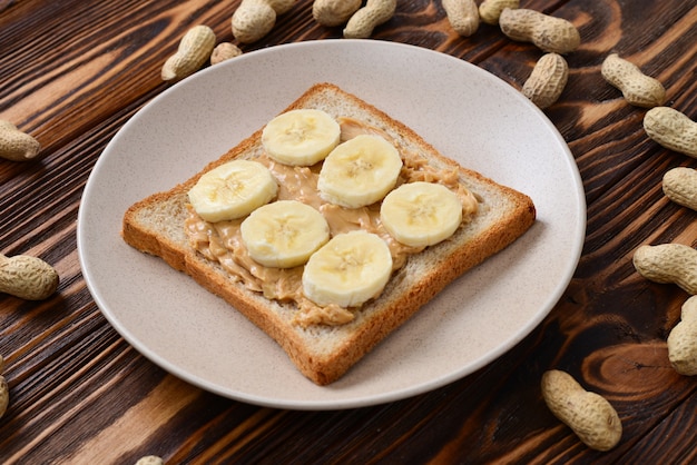 Peanut butter toast with banana slices  on wooden background