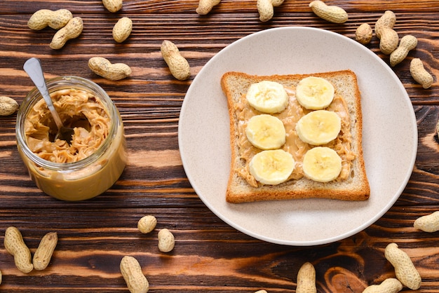 Peanut butter toast with banana slices  on wooden background