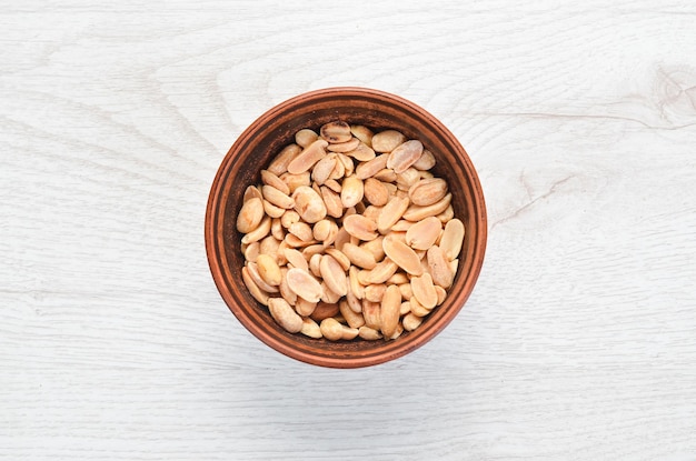 Peanuts in bowl on old table Nut background Top view