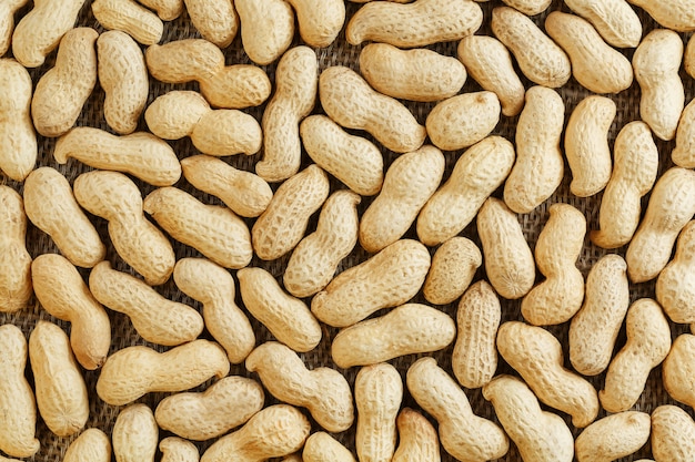 Peanuts in their shell textured food background.