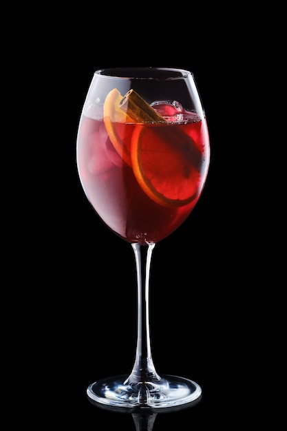 Pear and apple sangria in a wine glass isolated on black surface