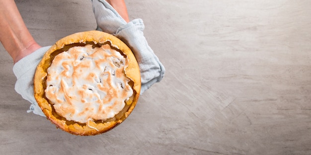 Pear pie on blue napkin in female hands. Copy space.