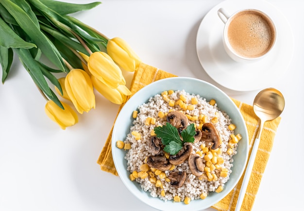 Pearl barley porridge with mushrooms and corn, healthy food concept, breakfast, cup with black coffee