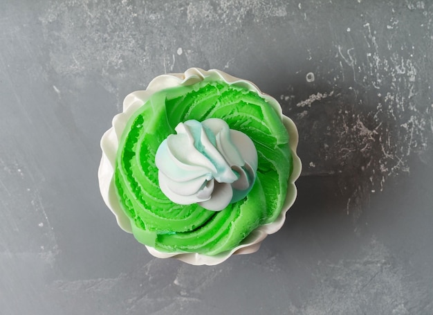 Pearl birthday cupcake with butter cream icing on gray background top view