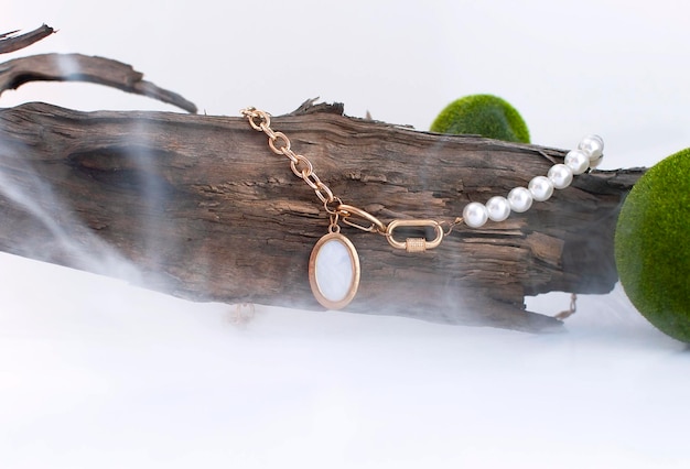 Pearl necklace on a tree with smoke in the foreground Pearls on a white background with a copy space Jewelry from a necklace in the studio