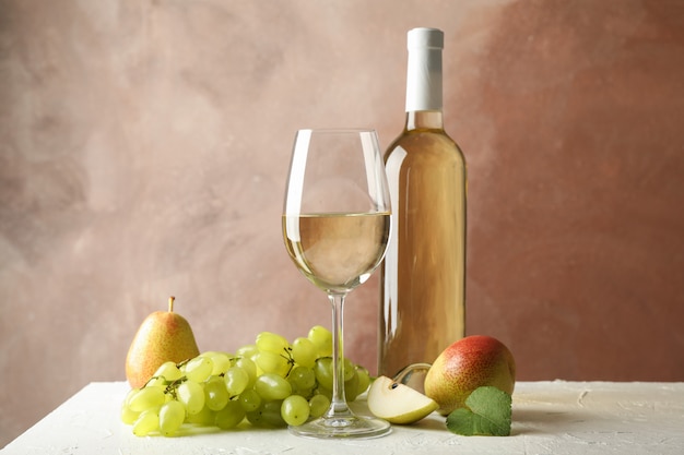 Pears, grape, bottle and glass with wine on white