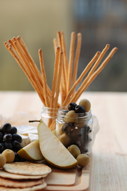 Pears and olives on a wooden board