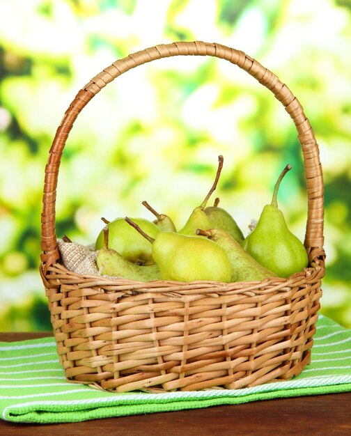 Pears in wicker basket on bright background