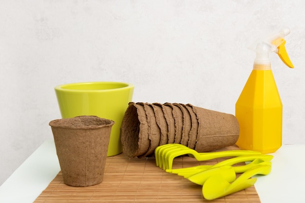 Peat pots rake shovels for planting sprinkler with water on a white background planting seedlings