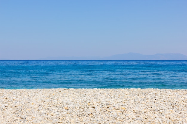 Pebble beach and blue sky. Life balance and harmony. Summer vacation concept. Minimalism