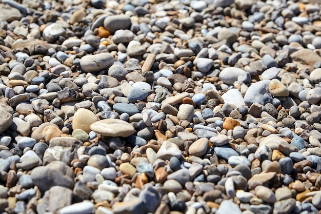 Pebble beach with smooth multicolored sea stones summer background