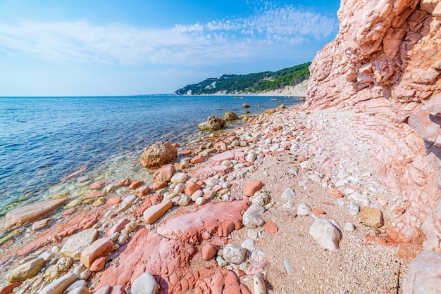 Pebbles beach colorful bay in Conero natural park dramatic coast headland rock cliff adriatic sea tourism destination Italy turquoise transparent water