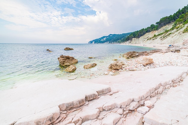 Pebbles beach colorful bay in Conero natural park dramatic coast headland rock cliff adriatic sea tourism destination Italy turquoise transparent water