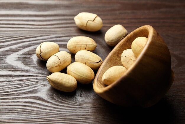 Pecan nuts in bowl on brown wooden table