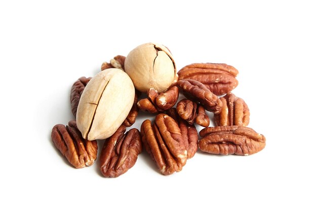 Pecan nuts in shell and peeled pecan halves isolated on a white Whole and halves of pecan nuts