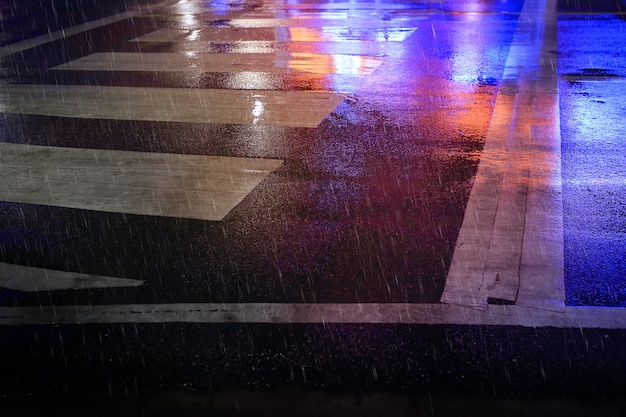 Pedestrian crossing (zebra traffic walk way) on the wet road  ,Rainy night in the city.