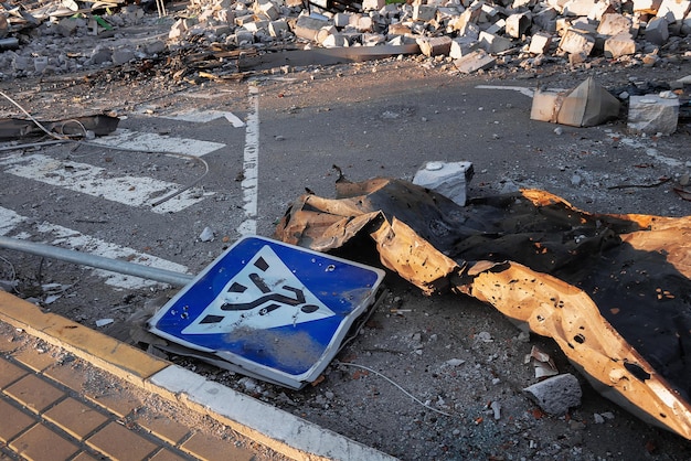 Pedestrian sign lying near ruined shopping mall as a result of mortar shelling