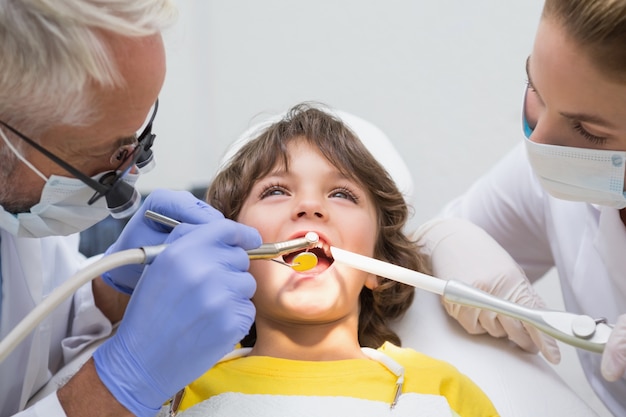 Pediatric dentist and assistant examining a little boys teeth 