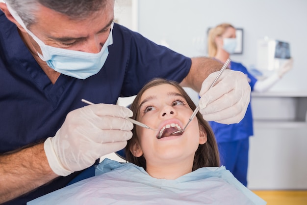 Pediatric dentist examining her young patient 