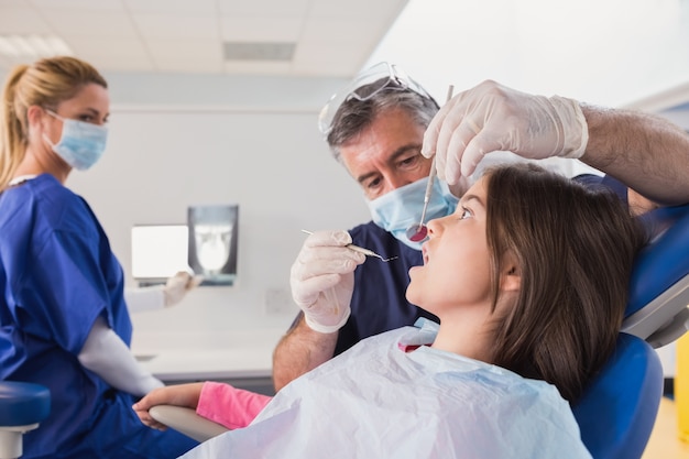 Pediatric dentist examining her young patient 