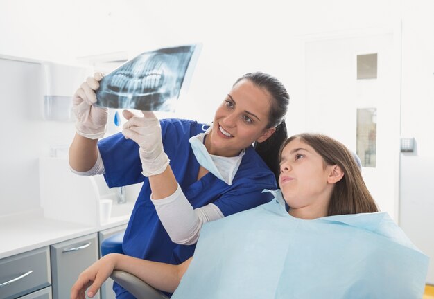 Pediatric dentist explaining to young patient the x-ray