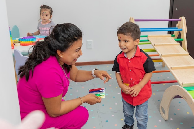 Pediatric doctor laughing with a child in the play area of her medical office