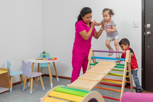 Pediatric doctor playing with a boy and a girl in the playroom of her office