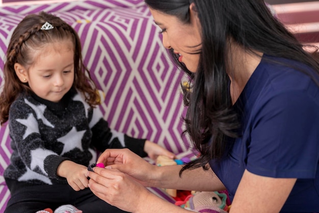 Pediatrician checks a child with an oximeter in her medical office