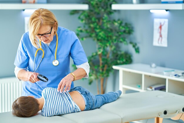 Pediatrician doctor examining little kids in clinic ears check. High quality photo