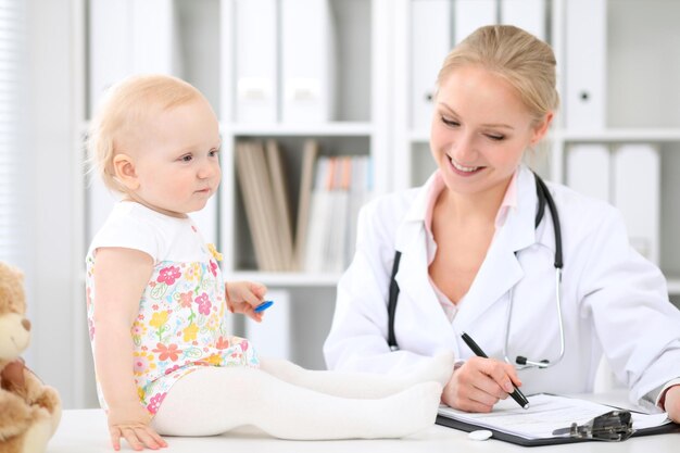 Pediatrician is taking care of baby in hospital Little girl is being examine by doctor with stethoscope