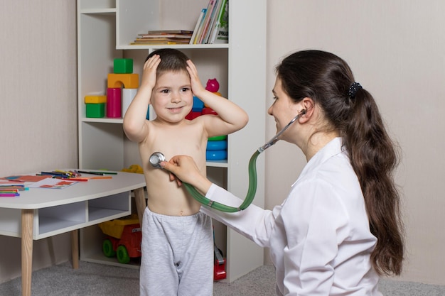 The pediatrician will auscultize the lungs and heart of a little boy