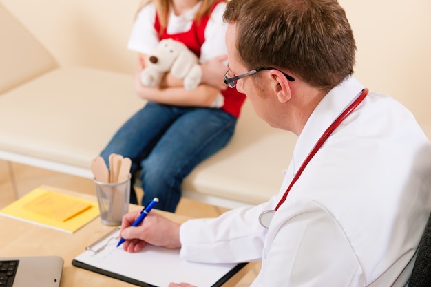 Pediatrician with little patient in his surgery