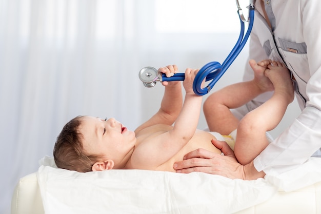 Pediatrics, a doctor examines a baby boy and uses a stethoscope to listen to the child's breathing, the concept of medicine and health