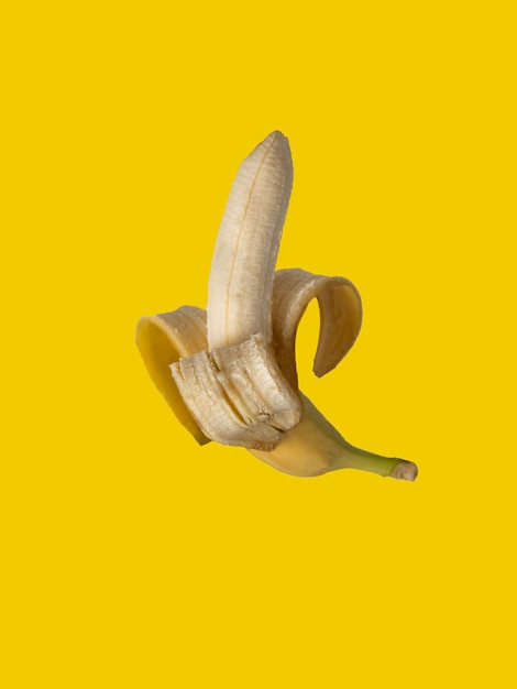 Peeled banana on a yellow background