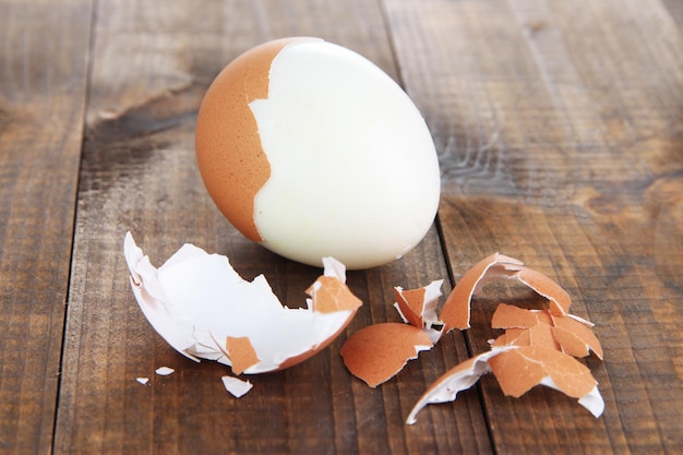 Peeled boiled egg on wooden background