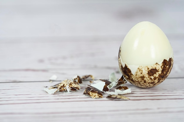 Peeled hard boiled quail egg with broken shell