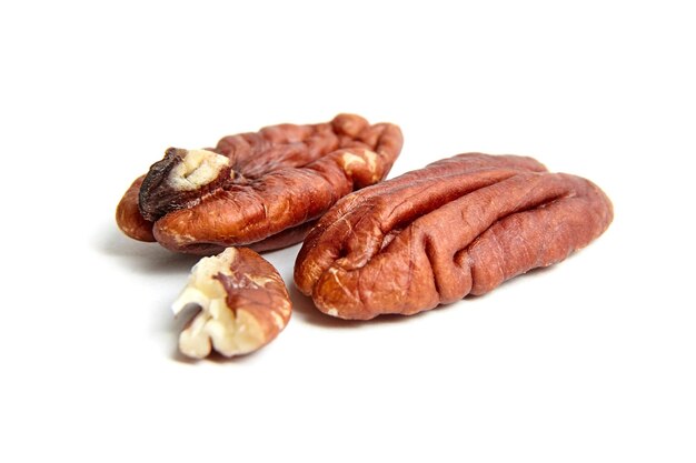 Peeled pecan nuts isolated on a white background Heap of pecan halves closeup