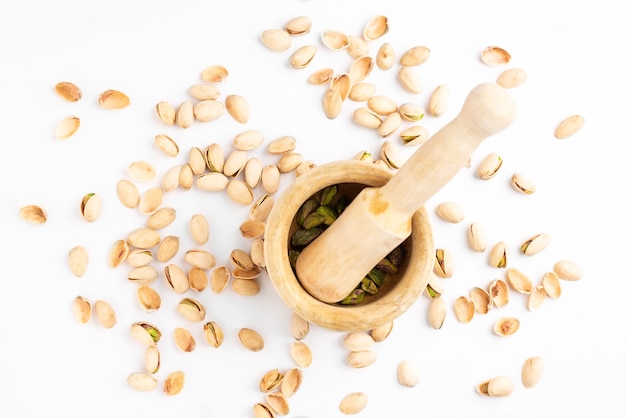 Peeled pistachios in mortar on a white.