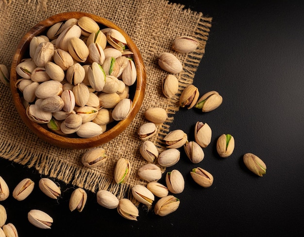 peeled pistachios in a wooden bowl closeup of green peeled pistachio nuts