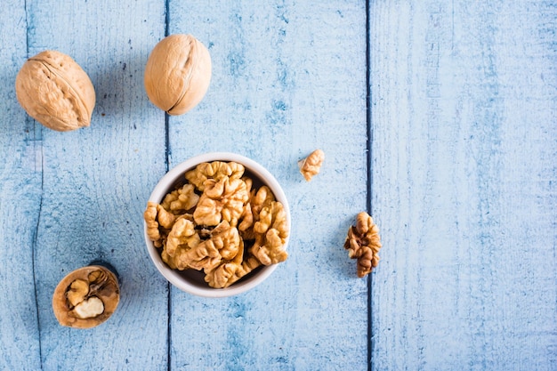 Peeled walnuts in a bowl on the table Organic food Top view